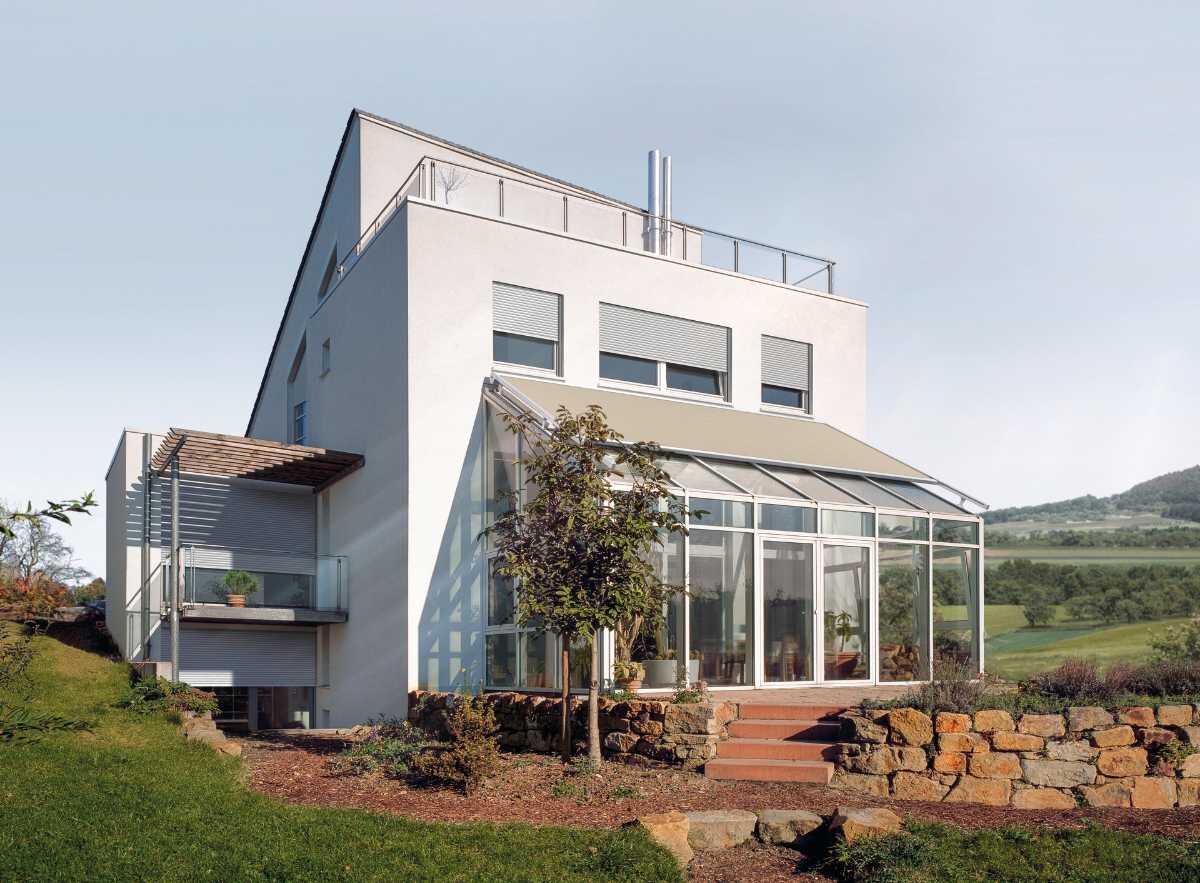 Elegantes Einfamilienhaus mit Wintergarten und Wintergartenmarkise Modernes Einfamilienhaus mit Wintergarten und Gartenlandschaft